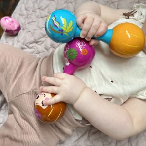 podgy little baby hands cling to colourful musical instruments