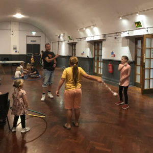 children are being shown how to swing their poi by Citrus Arts